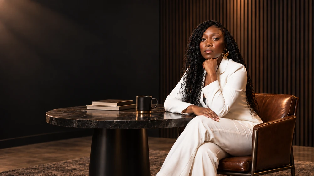 Professional portrait of a woman in a white suit.